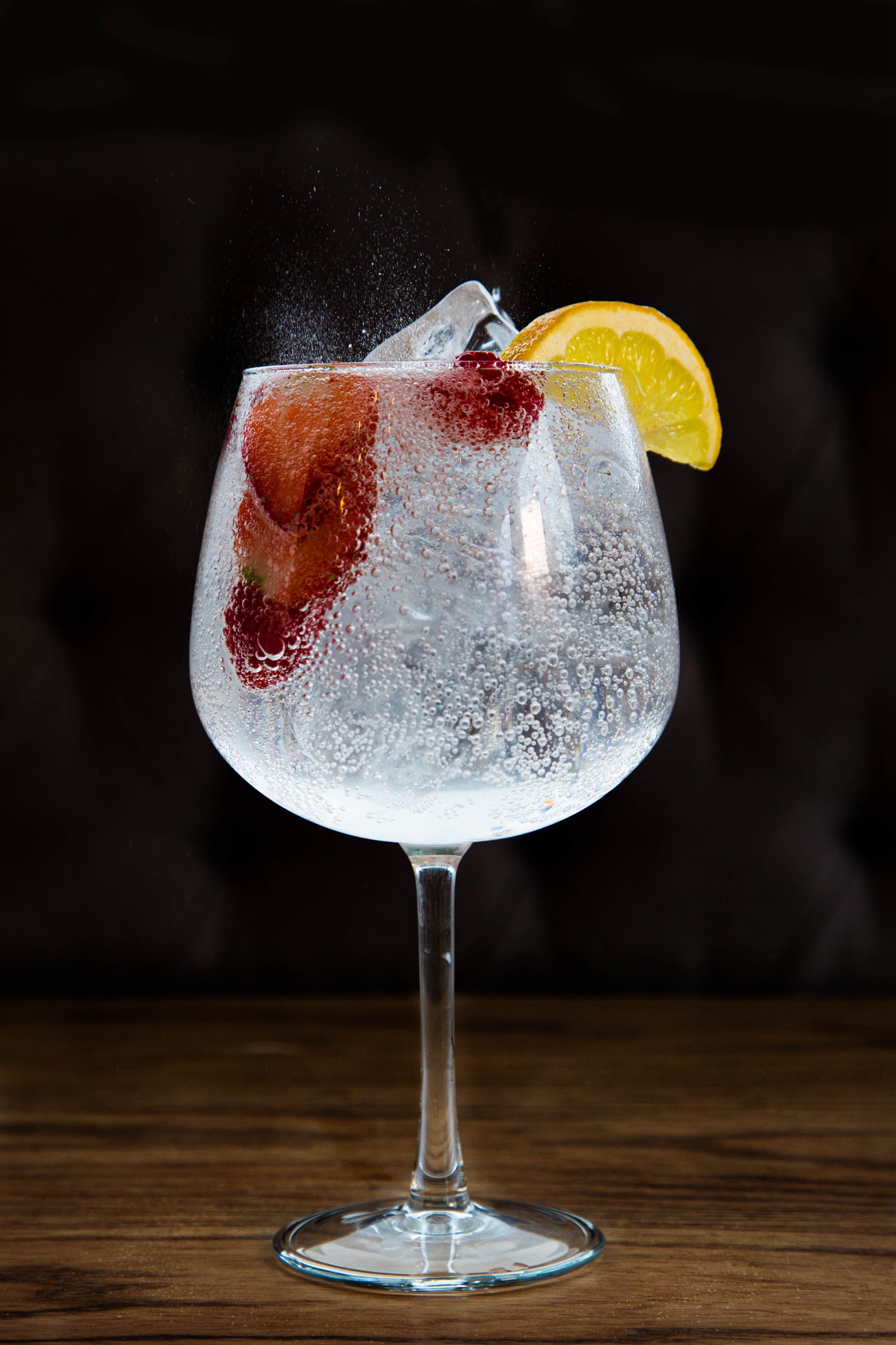 Gin cocktail with berries and citrus garnish